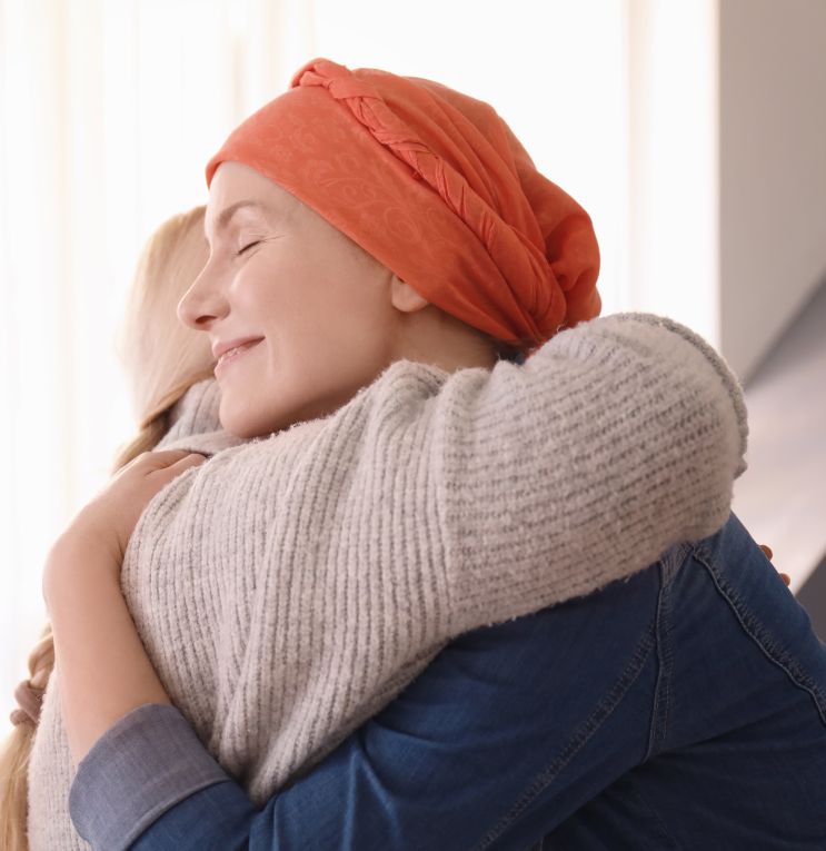 Cancer Patient In A Headscarf Hugging A Friend