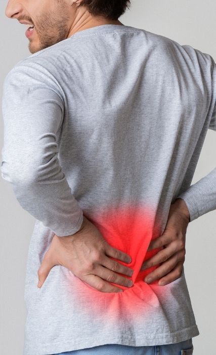 Man Holding Lower Back In Pain
